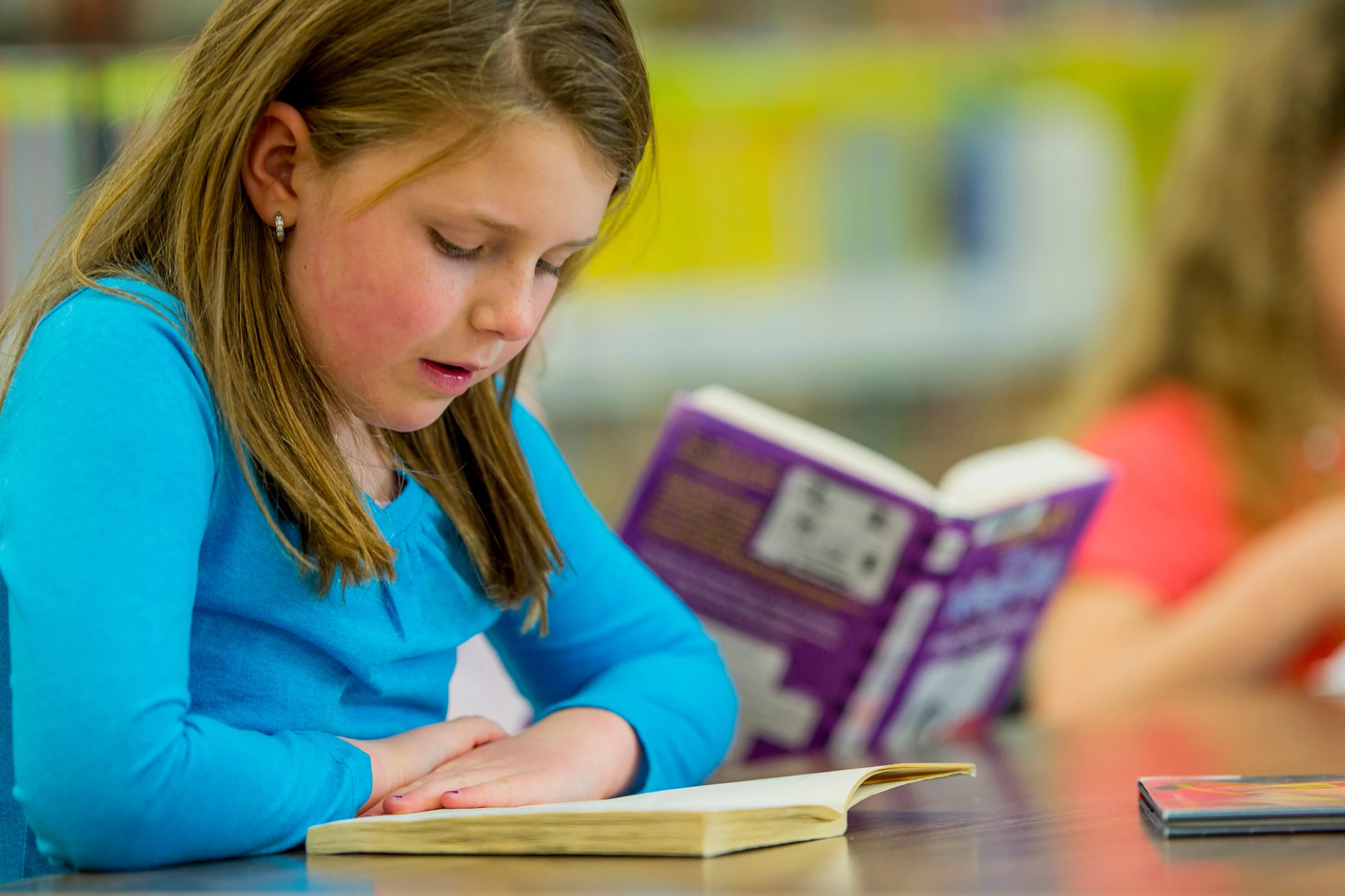 Girl reading a book at her desk