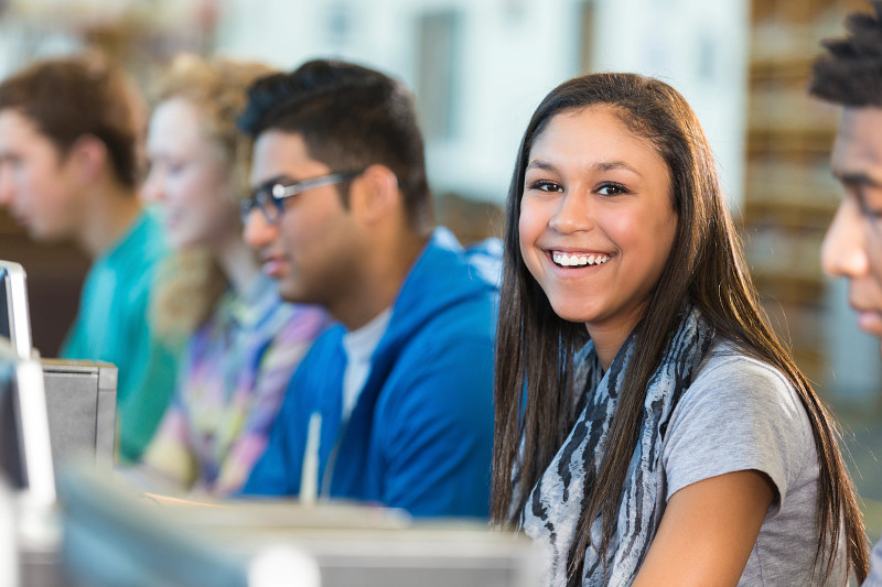 High School Student Smiling at Desk