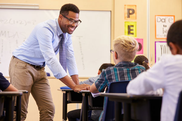 Teacher smiling and speaking with students