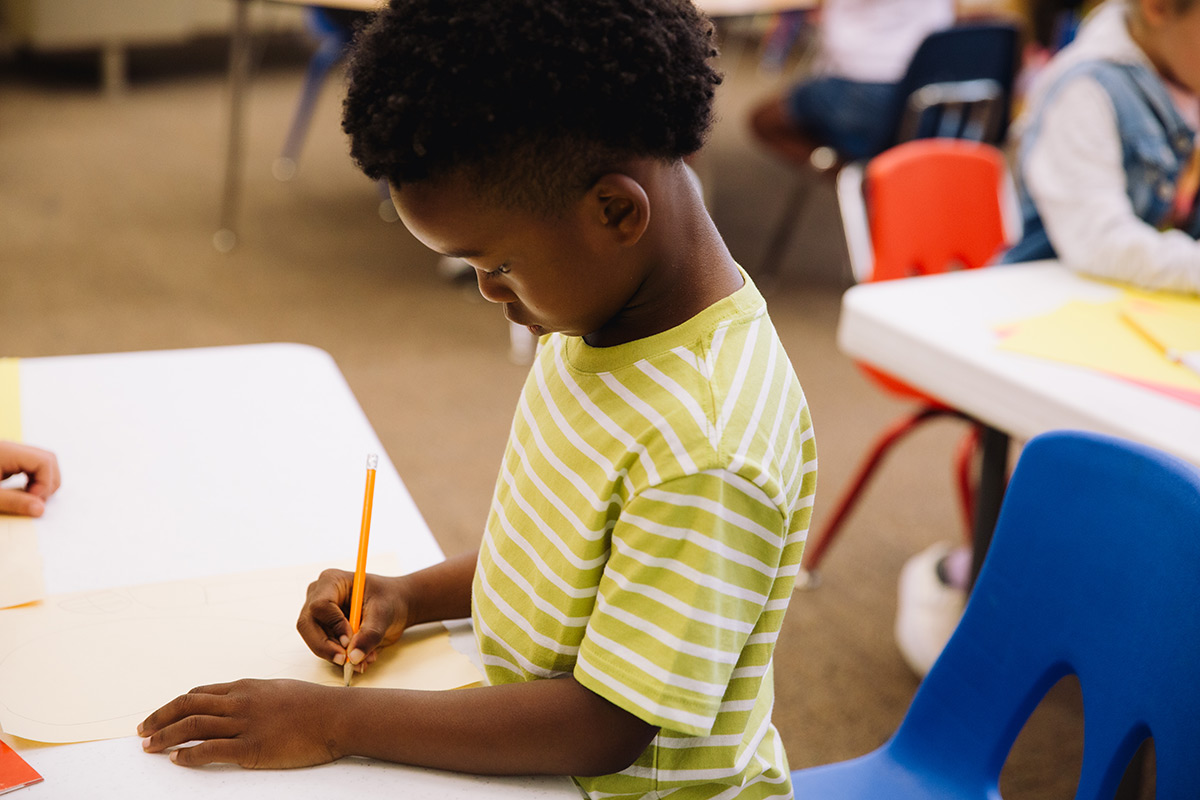 Student writing at his desk