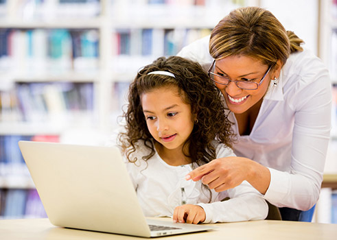 Teacher and student looking at laptop