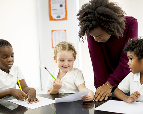 Students with teacher at desk