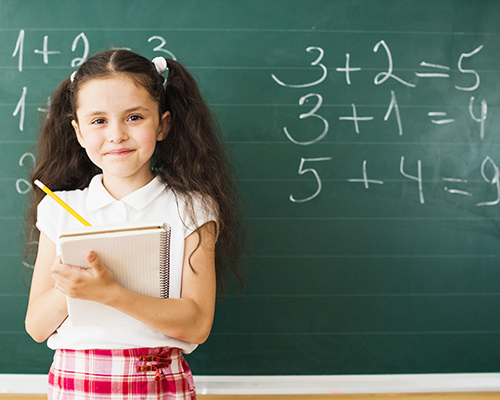 Student standing in fron of chalk board with math equationss
