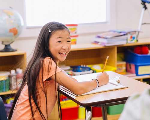Student smiling at desk