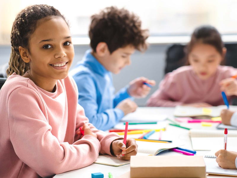 SUTW students at desk with girl smiling