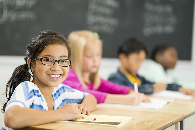Acadience student smiling at desk