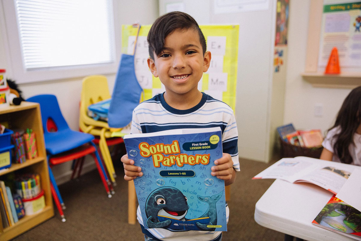 Student holding a Sound Partners Book